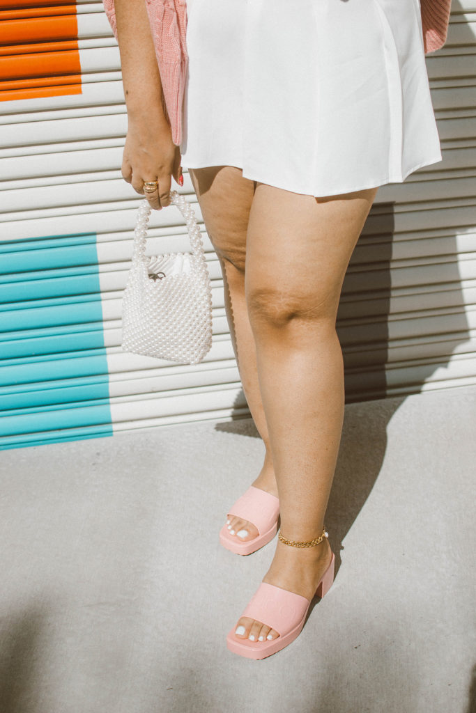 Valentine’s Day Outfit Inspiration: Pink cable knit cardigan and bralet set from River Island, white pleated tennis skirt, Gucci Woman’s rubber slide sandal 