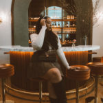 Girl sitting at the art deco inspired bar at Le Bon Nosh located in the Buckhead neighborhood of Atlanta.